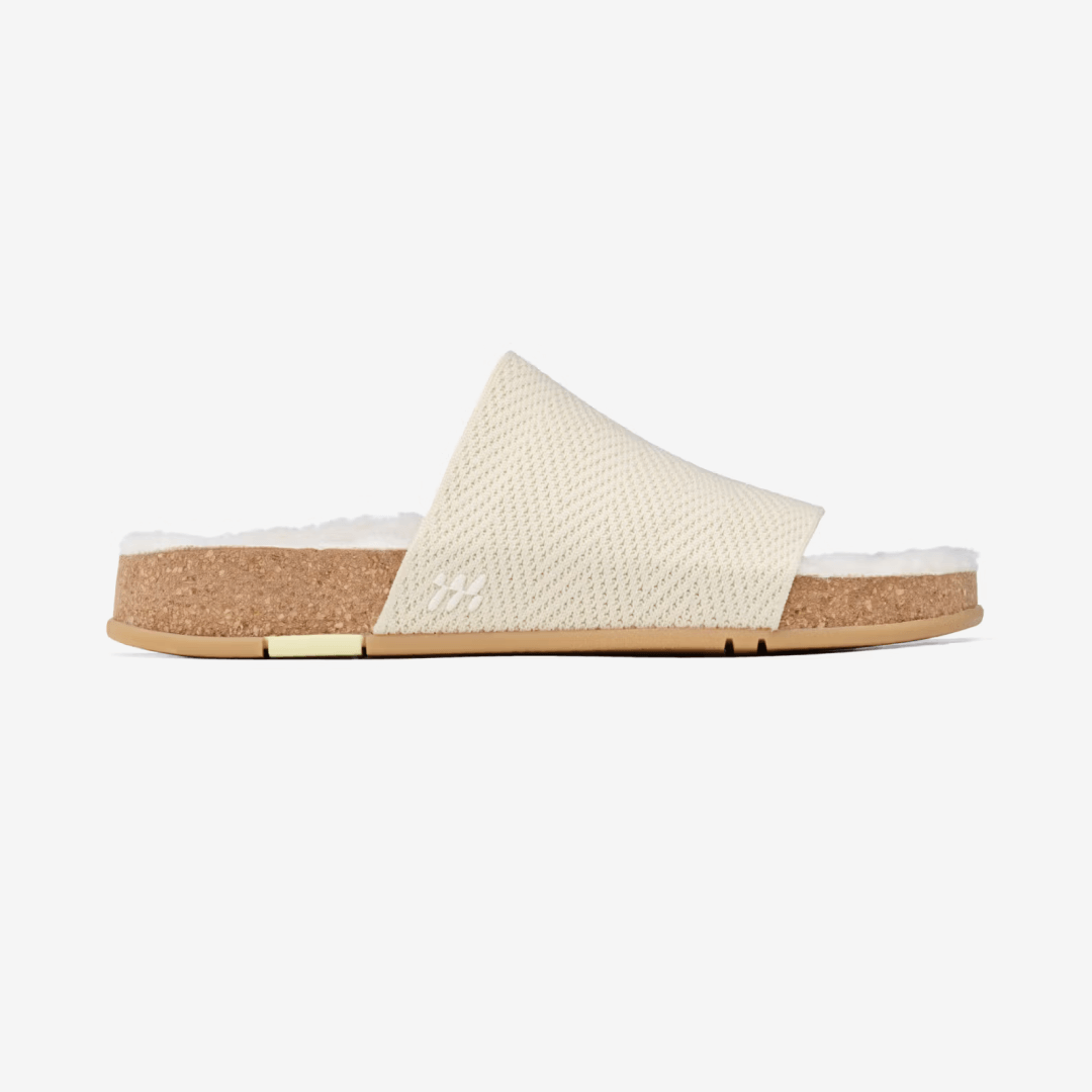 Showcasing the side view of Shaw Cozy Slide in Creme. Featuring Vegan eco-shearling™️ recycled cotton custom blend