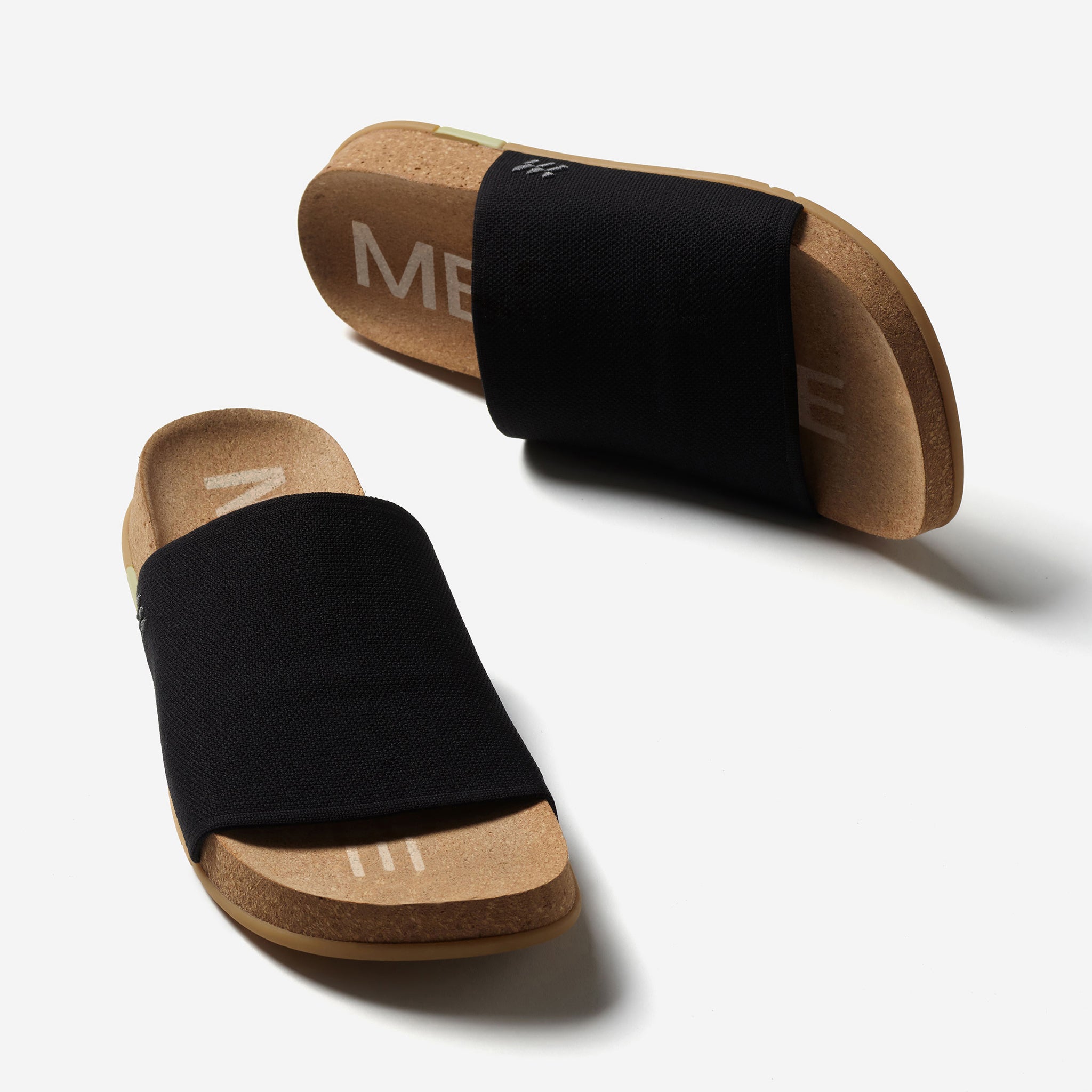Pair of black sandals with cork soles on a white background