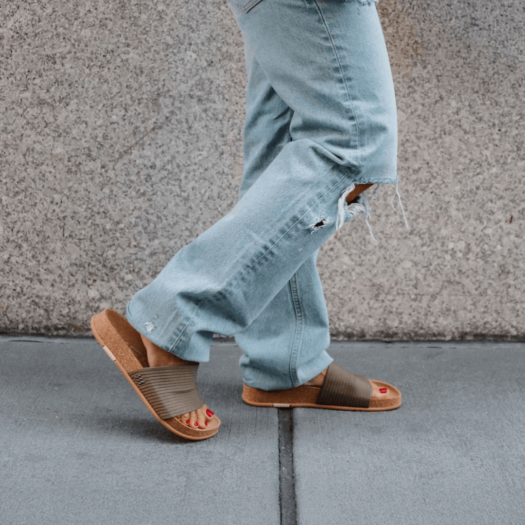 Woman walking in the park wearing stone Mullen Ripple Slides