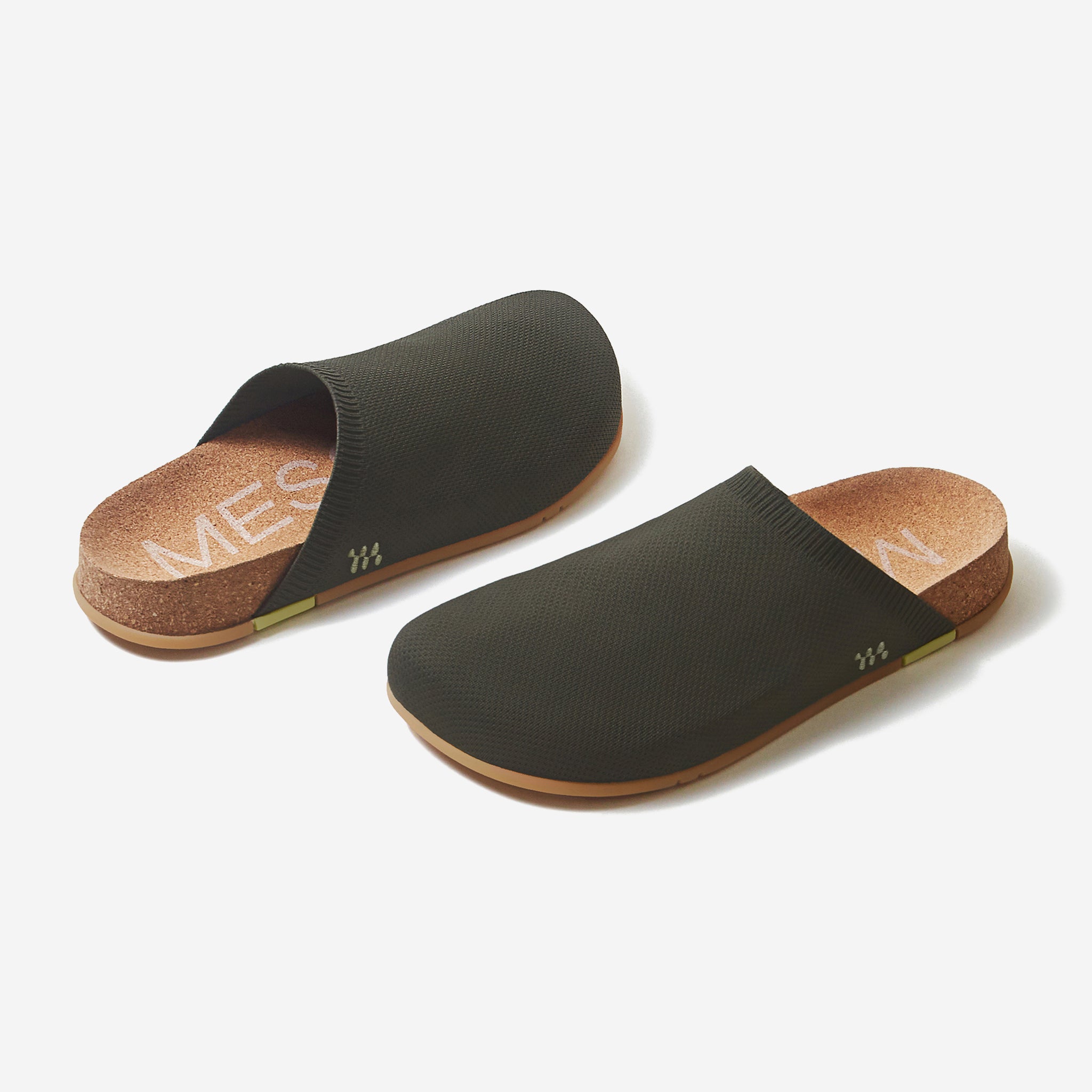 Pair of black slides with cork soles on a white background