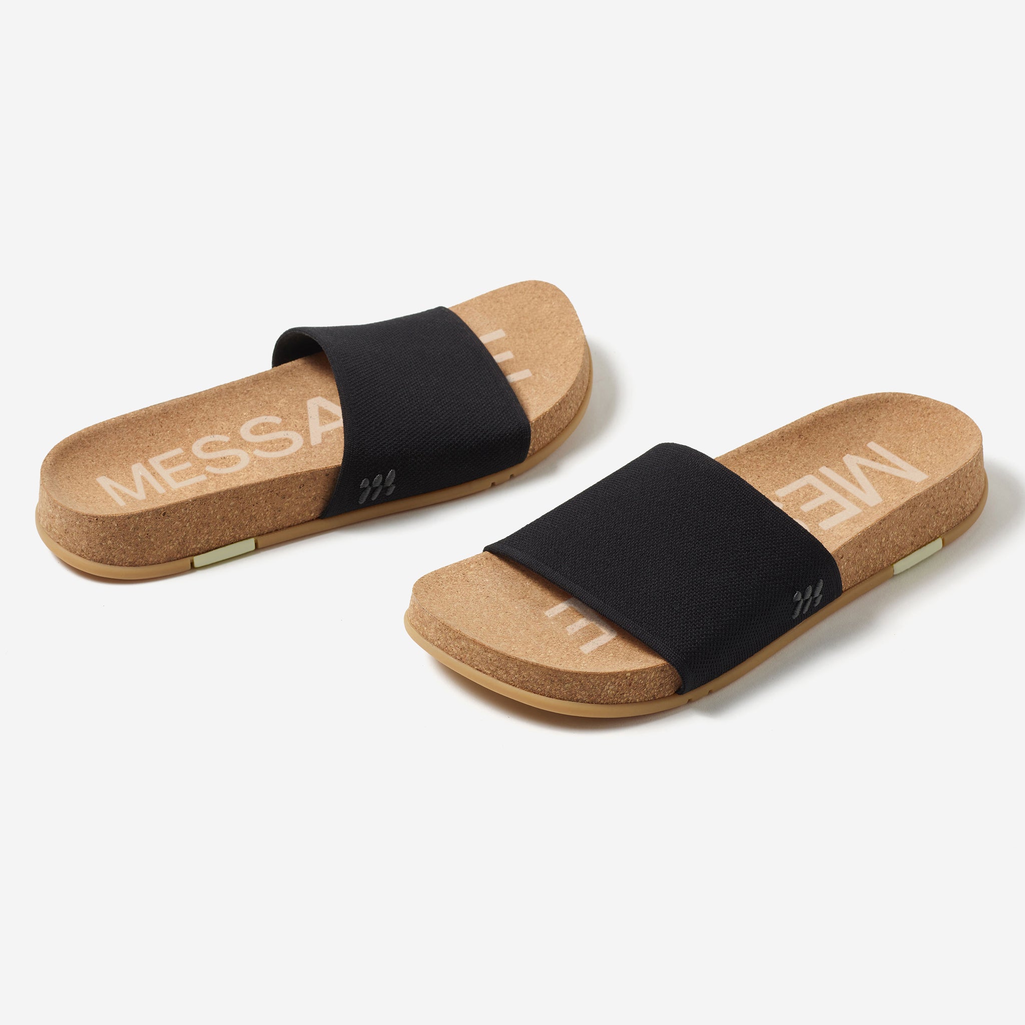 Pair of cork sandals with black straps on a white background